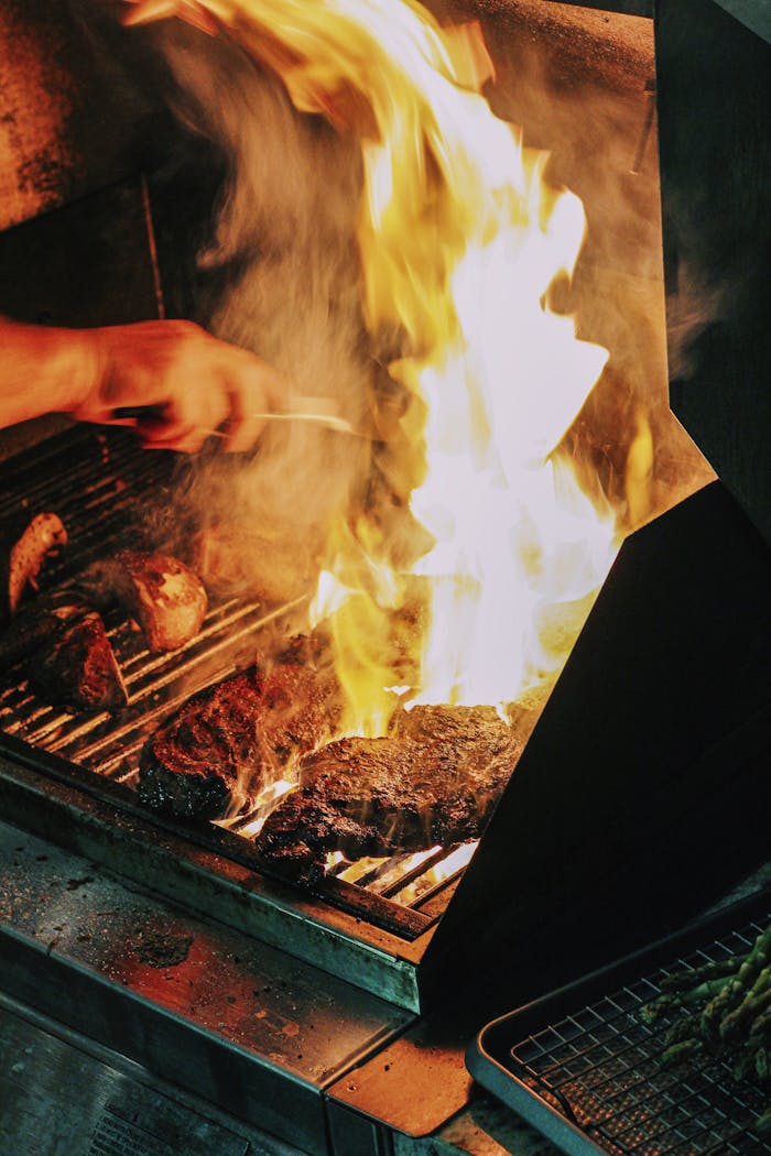 services-04 Close-up of steak grilling over high flames, a classic Atlanta barbecue scene.