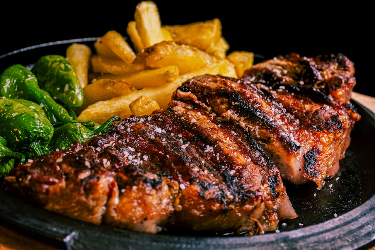 services-03 Succulent grilled steak served with crispy fries and roasted green peppers.